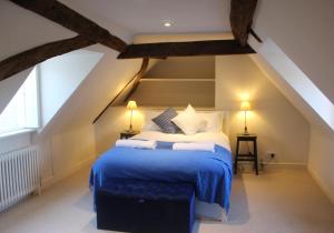1 dormitorio con 1 cama con manta azul en West Pallant Georgian Townhouse in City Centre with Courtyards, BBQ & Log Burners - Dogs Welcome! - Chichester Holiday Properties en Chichester