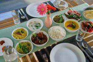 una mesa cubierta con platos de comida en una mesa en PANCHAVADI FARM STAY, en Thekkady