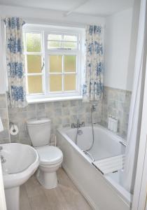 a bathroom with a toilet and a tub and a sink at Georgian 2 bedroom Apartment, Near Chichester with free Parking in Chichester
