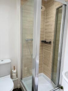 a bathroom with a shower with a toilet and a sink at Spacious Retreat with Parking: Ideal for Families & Contractors in York