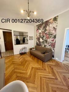 een woonkamer met een bank en een houten vloer bij La Casa di Titilla in Turijn
