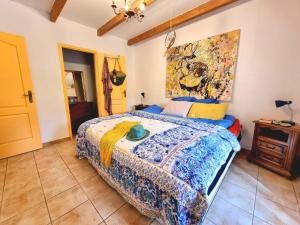 a bedroom with a bed and a painting on the wall at La Maison de Blu in Lorgues