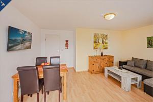 a living room with a couch and a table at Waldsiedlung Waldhaus App 4.1 in Korswandt