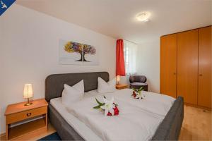 una camera da letto con un letto fiorito di Waldsiedlung Waldhaus App 4.1 a Korswandt