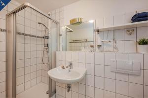 bagno bianco con lavandino e doccia di Waldsiedlung Waldhaus App 4.1 a Korswandt