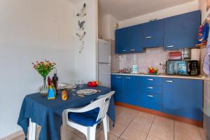 a small kitchen with blue cabinets and a table with chairs at PALAIS DES ARTS AP4399 By Riviera holiday homes in Nice