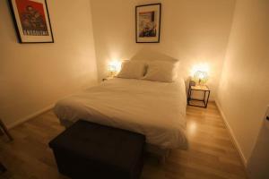 a bedroom with a bed with two lights on it at Le St Ausone : Studio Centre Ville/parking in Angoulême