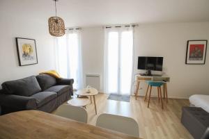 a living room with a couch and a tv at Le St Ausone : Studio Centre Ville/parking in Angoulême