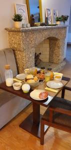 a table with plates of food and a fireplace at Villam Natura & Spa in Vila Nova de Famalicão