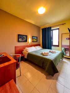 a bedroom with a bed and a table and a chair at Hotel Erbaluce in Caluso