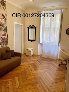 een woonkamer met een bank en een houten vloer bij La Casa di Titilla in Turijn