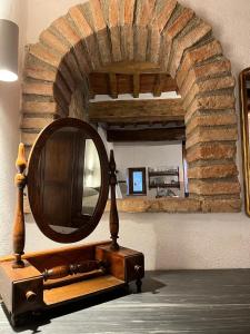 - un miroir rond assis sur une table dans une pièce dans l'établissement L' Antico Lavatoio, à Pitigliano