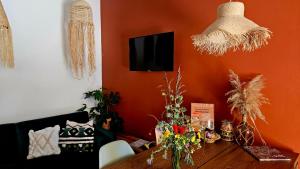 una sala de estar con paredes de color naranja y una mesa de madera con flores. en La Estación del Amor en Alora