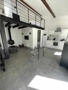 ein Wohnzimmer mit einem Glastisch und einem Kühlschrank in der Unterkunft Petite Maison à la Loubiere avec jardin, clim et parking in Toulon