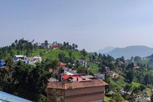 a village on a hill with houses on it at All Seasons, luxury villa in Kotagiri