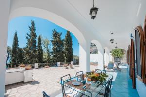 un patio con mesa, sillas y un arco en Villa Capri by MyVillaCollection, en Capri 30 fotos más