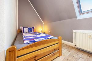 ein kleines Schlafzimmer mit einem Bett in einem Zimmer in der Unterkunft Seeadler 11 in Buchholz