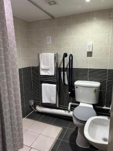 a bathroom with a toilet and a sink at Redwings Lodge Birmingham in Oldbury