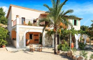 una casa con una palmera delante de ella en Sa Fontasa, en Moscari