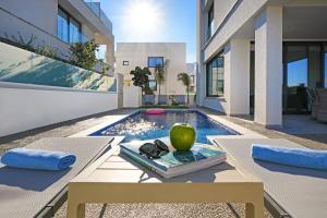 een villa met een zwembad en een tafel met een groene appel bij Villa Theresa in Protaras