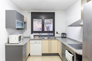 cocina blanca con fregadero y microondas en AndBnB I 3 Habitaciones con Terraza y Parking en Ordino