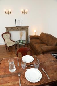 d'un salon doté d'une table avec des plaques blanches. dans l'établissement Appartements 4 vents by La Boîte En Plus, à Senlis