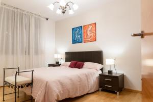 オルディノにあるAndBnB I 3 Habitaciones con Terraza y Parkingのベッドルーム1室(ベッド1台、テーブル2台、椅子付)
