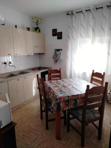 eine Küche mit einem Tisch und Stühlen sowie einem Tisch und einer Küche in der Unterkunft Appartamento al Lago in Levico Terme