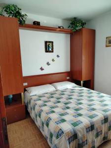 レーヴィコ・テルメにあるAppartamento al Lagoのベッドルーム1室(ベッド1台付)、壁に植物2本