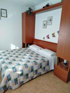 ein Schlafzimmer mit einem Bett mit einer karierten Decke in der Unterkunft Appartamento al Lago in Levico Terme