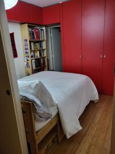 um quarto com paredes vermelhas e uma cama branca em Excellent Appart totalement rénové em Paris