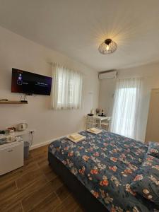 - une chambre avec un lit et une télévision murale dans l'établissement Room Ela, à Donji Seget