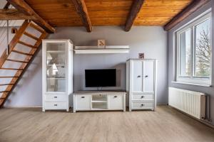 een woonkamer met een witte kast en een tv bij Kranichhorst 7 in Buchholz