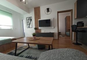 a living room with a table and a tv at Mango Apartments in Gevgelija