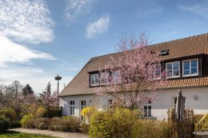 een huis met een bloeiende boom ervoor bij Kranichhorst 7 in Buchholz