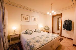 Capriva del FriuliにあるAppartamenti nelle Vigneのベッドルーム(白いベッド1台、鏡付)