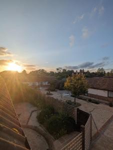 a view of a sunset over a courtyard with a fence at Kingfisher Barn B&B in Abingdon