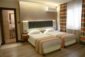 En eller flere senge i et værelse på Fimka Hotel