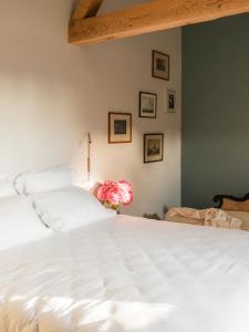 a bedroom with a white bed and some pictures on the wall at Petit Chateau Vercourt in Vercourt
