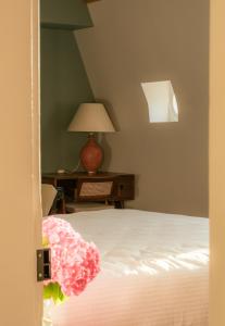 a bedroom with a bed and a desk with a lamp at Petit Chateau Vercourt in Vercourt