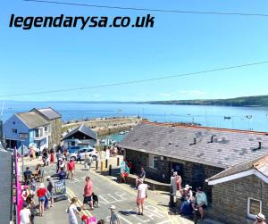a group of people walking around a pier at Harbour Lights Apartment New Quay in New Quay