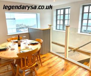 d'une salle à manger avec une table, des chaises et une fenêtre. dans l'établissement Harbour Lights Apartment New Quay, à New Quay