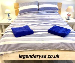 1 cama grande con 2 almohadas azules en Harbour Lights Apartment New Quay, en New Quay