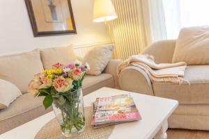 uma sala de estar com um vaso de flores numa mesa de centro em Villa Granitz Möwennest em Ostseebad Sellin