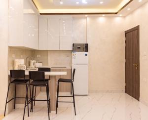a kitchen with white cabinets and a table and chairs at Prestige hotel apartment in Amman