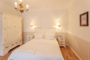 um quarto branco com uma cama e duas mesas de cabeceira em Villa Granitz Möwennest em Ostseebad Sellin