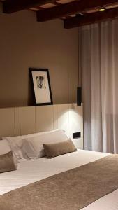 a bedroom with a large bed with white sheets at Hotel Vall de Bas in Joanetes