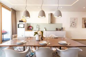 a dining room with a wooden table and white chairs at Villa Baltic Pearl Penthouse in Ostseebad Sellin +23 photos