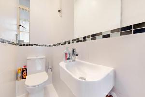 een witte badkamer met een toilet en een wastafel bij 3 bedroom Family Friendly Apartment in Hillcrest in Londen