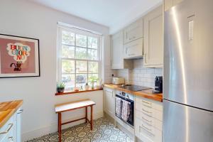 a kitchen with white cabinets and a stainless steel refrigerator at 3 bedroom Family Friendly Apartment in Hillcrest in London